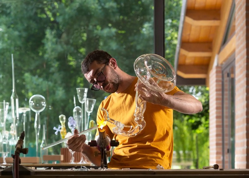 Simone Crestani working glass with a flame in his workshop